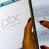Aplicativo de banco no celular e atrás uma tela escrito "pix"