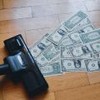 Imagem de aspirador drenando notas de dólar