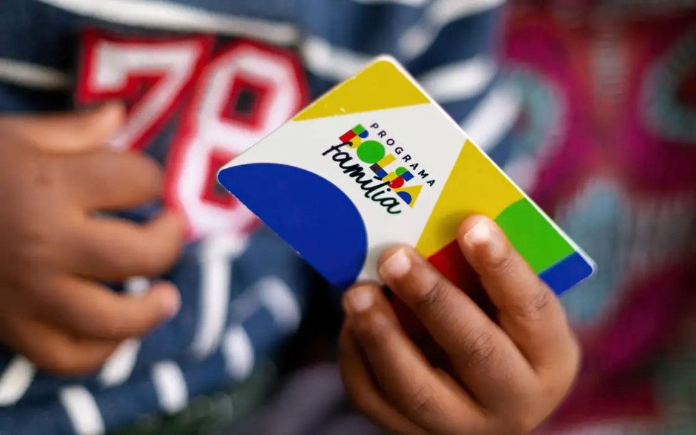 Criança com cartão do Bolsa Família