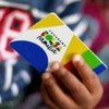 Criança segura cartão do Bolsa Família
