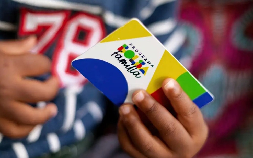 Criança segura cartão do Bolsa Família