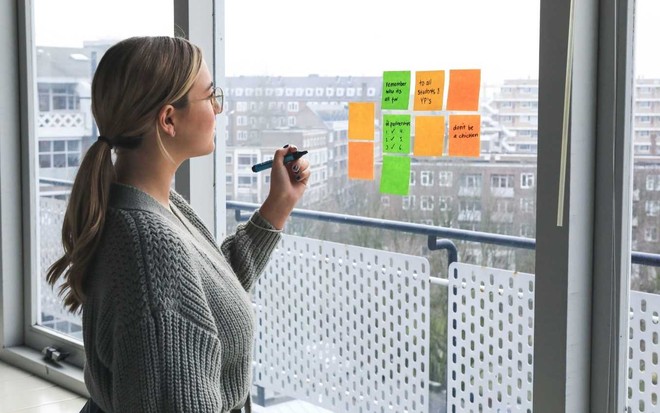 Imagem de mulher preenchendo post-its