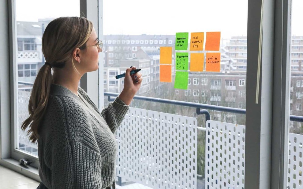 Imagem de mulher preenchendo post-its
