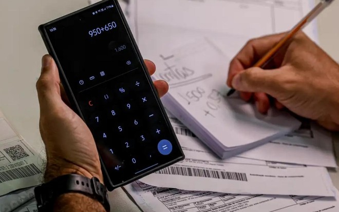 Pessoa usa calculadora para fazer contas