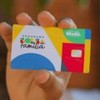 Mulher segura cartão do Bolsa Família