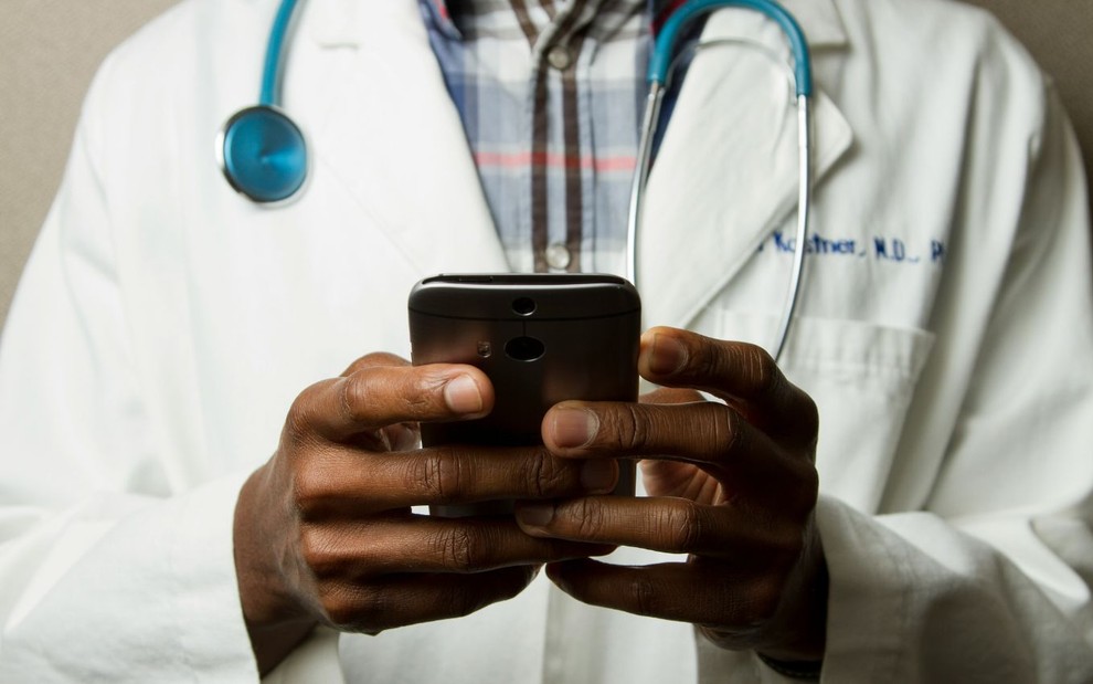 Médico mexendo em seu smartphone