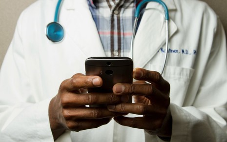 Médico mexendo em seu smartphone