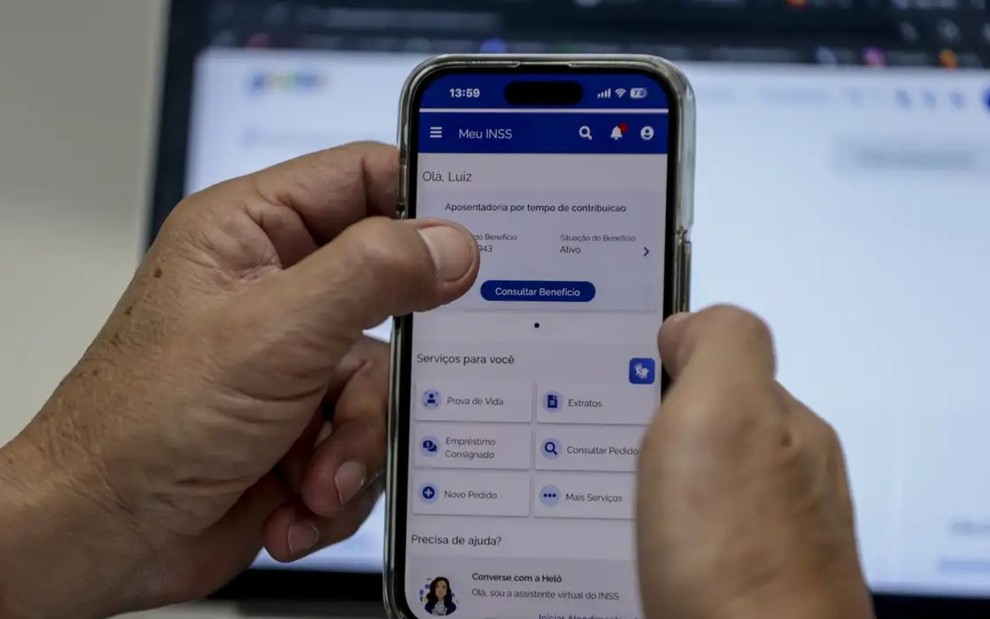 Mãos segurando um celular no site Meu INSS