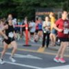 Homem observa pessoas em corrida de rua