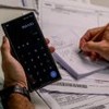 Pessoa segura calculadora e caneta