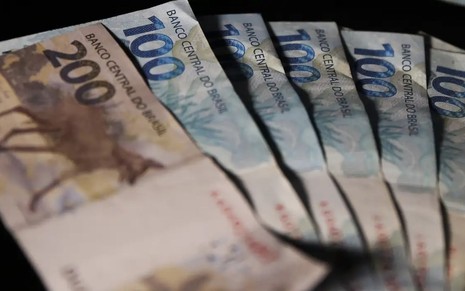 Cédulas de 100 e 200 reais com fundo preto