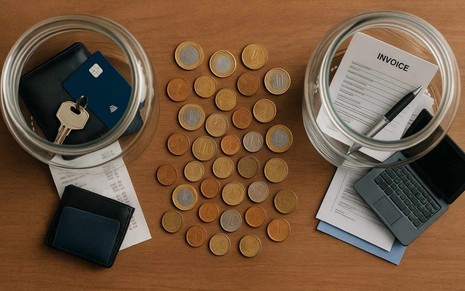 Dois potes simbolizam finanças pessoais e empresariais com moedas misturadas (imagem gerada por IA)