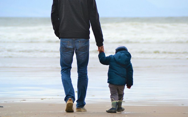 Pai e filho caminhando juntos na praia