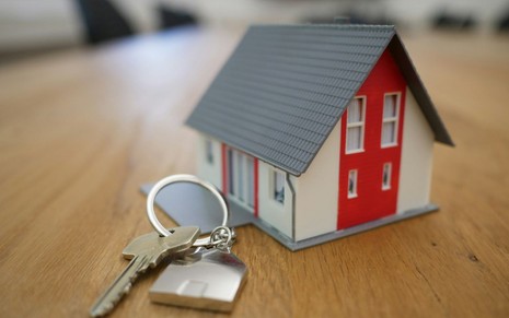 Miniatura de uma casa ao lado de um chave