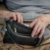 idosa segurando uma bolsa preta