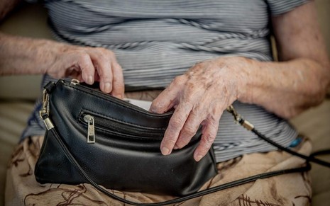 idosa segurando uma bolsa preta