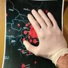 Mão vestindo luva branca posicionada em um mapa