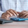 Homem faz contas na calculadora