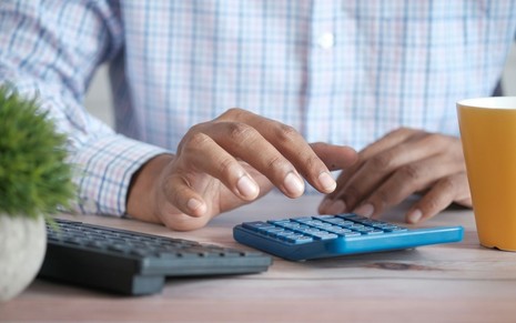 Homem faz contas na calculadora