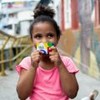 Menina segurando cartão do Bolsa Família