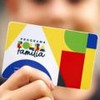 Menino segurando cartão do bolsa família