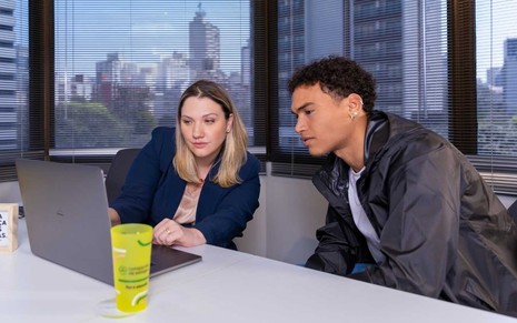 Estagiário recebe orientações de líder durante trabalho presencial