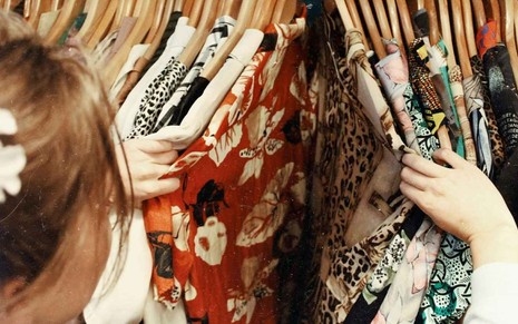 Mulher vê roupas em loja