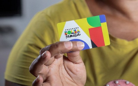Pessoa segura cartão do Bolsa Família