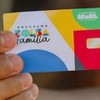 Pessoa segurando o cartão do Bolsa Família