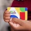 Um adulto e um bebe segurando o cartão do bolsa família