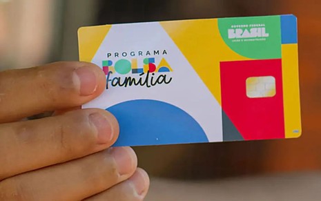 Criança segura cartão do Bolsa Família