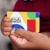 Criança segurando o cartão do Bolsa Família