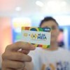 Rapaz segurando o cartão do  Pé-de-Meia
