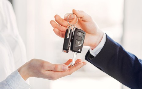 Pessoa recebendo chave de um carro