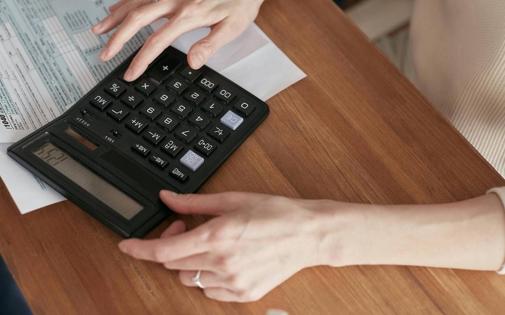 Pessoa faz conta em calculadora