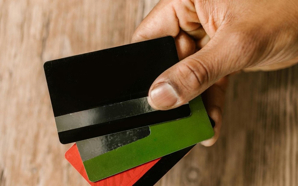 Imagem de pessoa segurando cartões de crédito