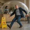 Homem escorrega em piso molhado dentro de café protegido por cúpula transparente.
