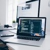 Imagem de notebook sobre a mesa com tela de programação