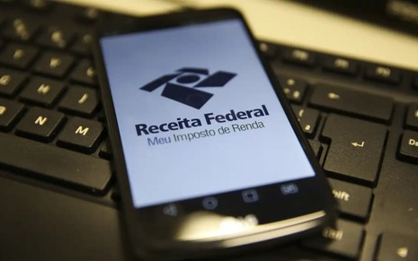 Celular ligado com a tela da Receita Federal