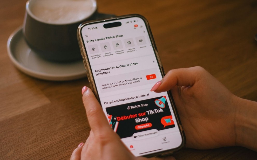 Mão segurando telefone com o app do TikTok Shop aberto