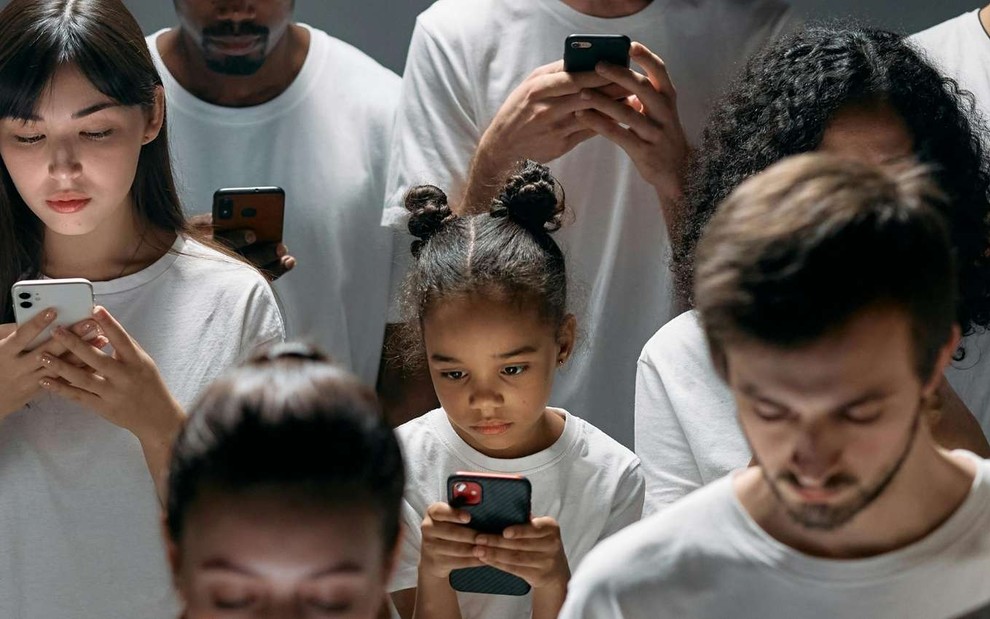 Imagem de pessoas de diferentes idades mexendo em celular